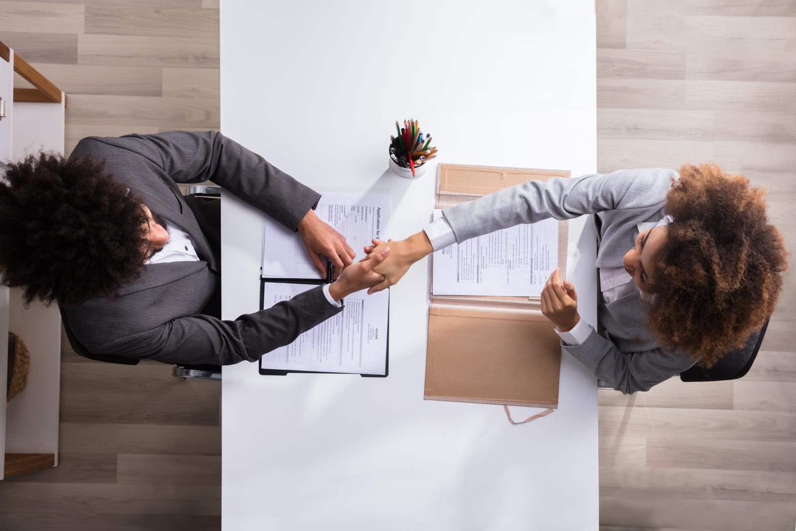 two people shaking hands over an agreement